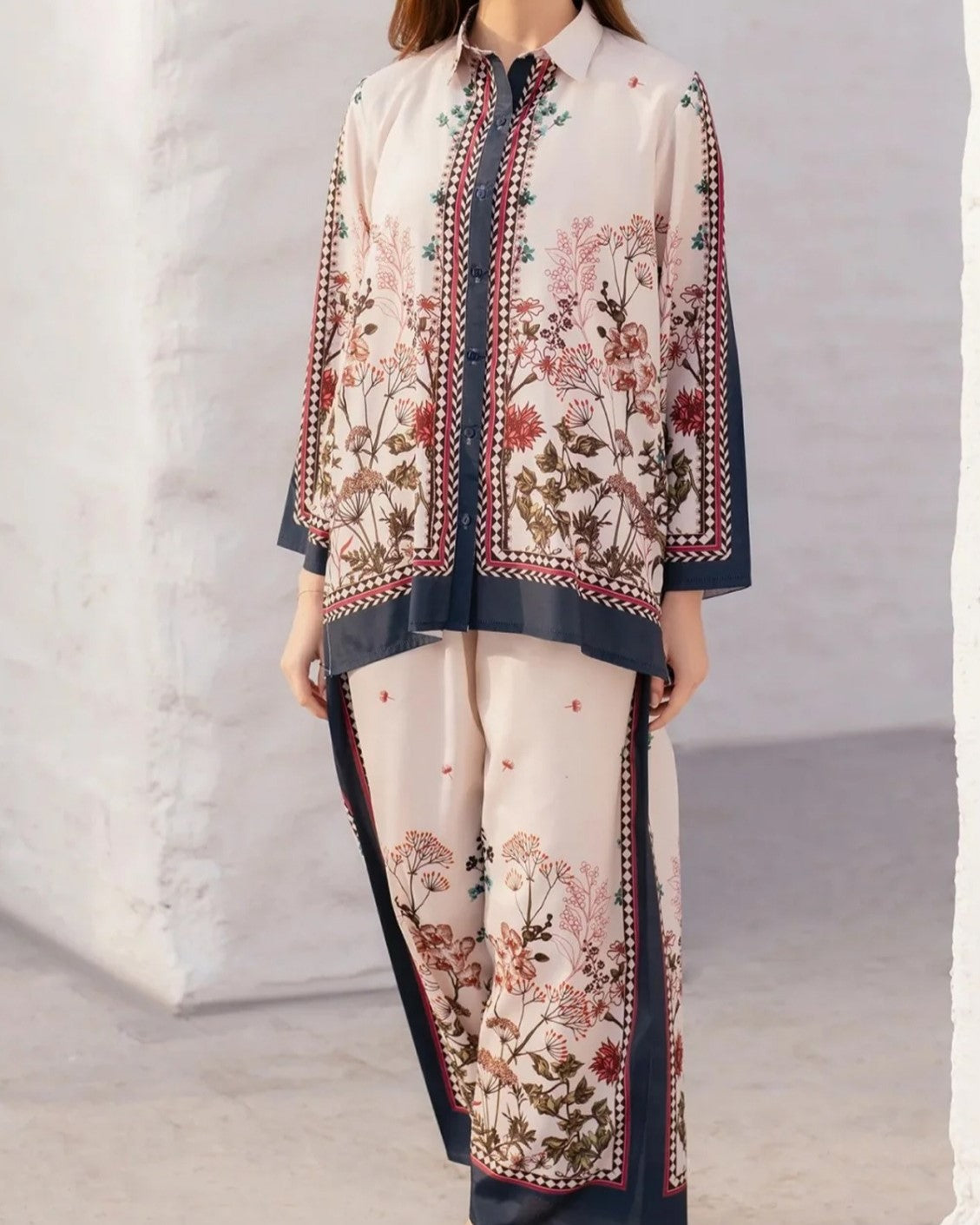 Woman wearing a floral embroidered outfit with a plain background