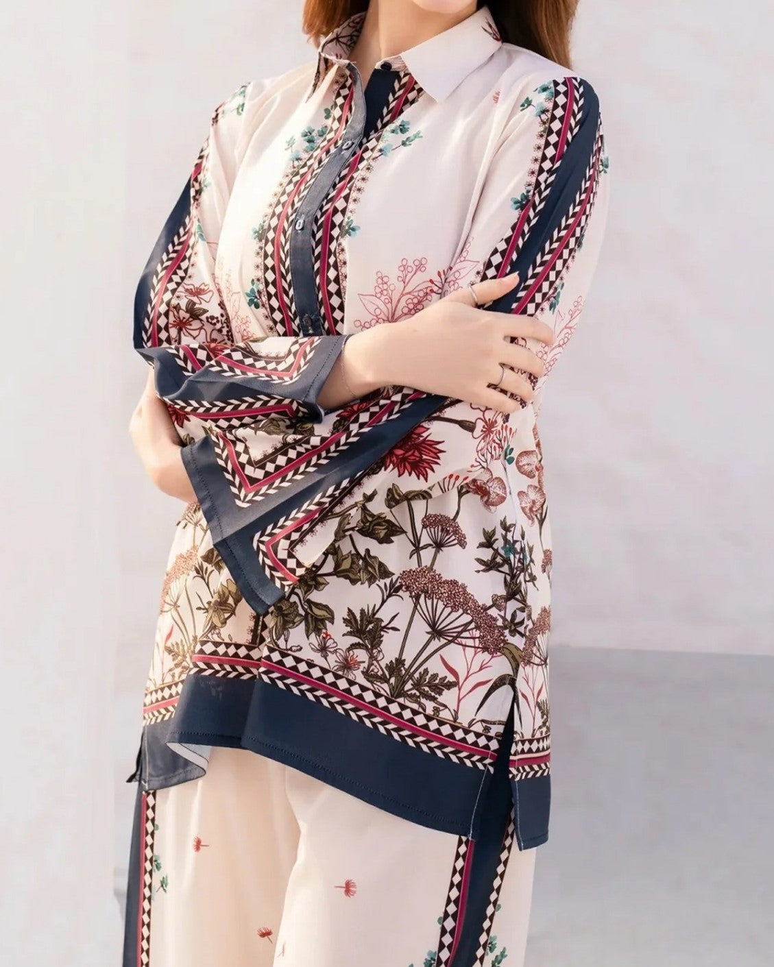 Person wearing a floral and geometric patterned shirt with a plain background