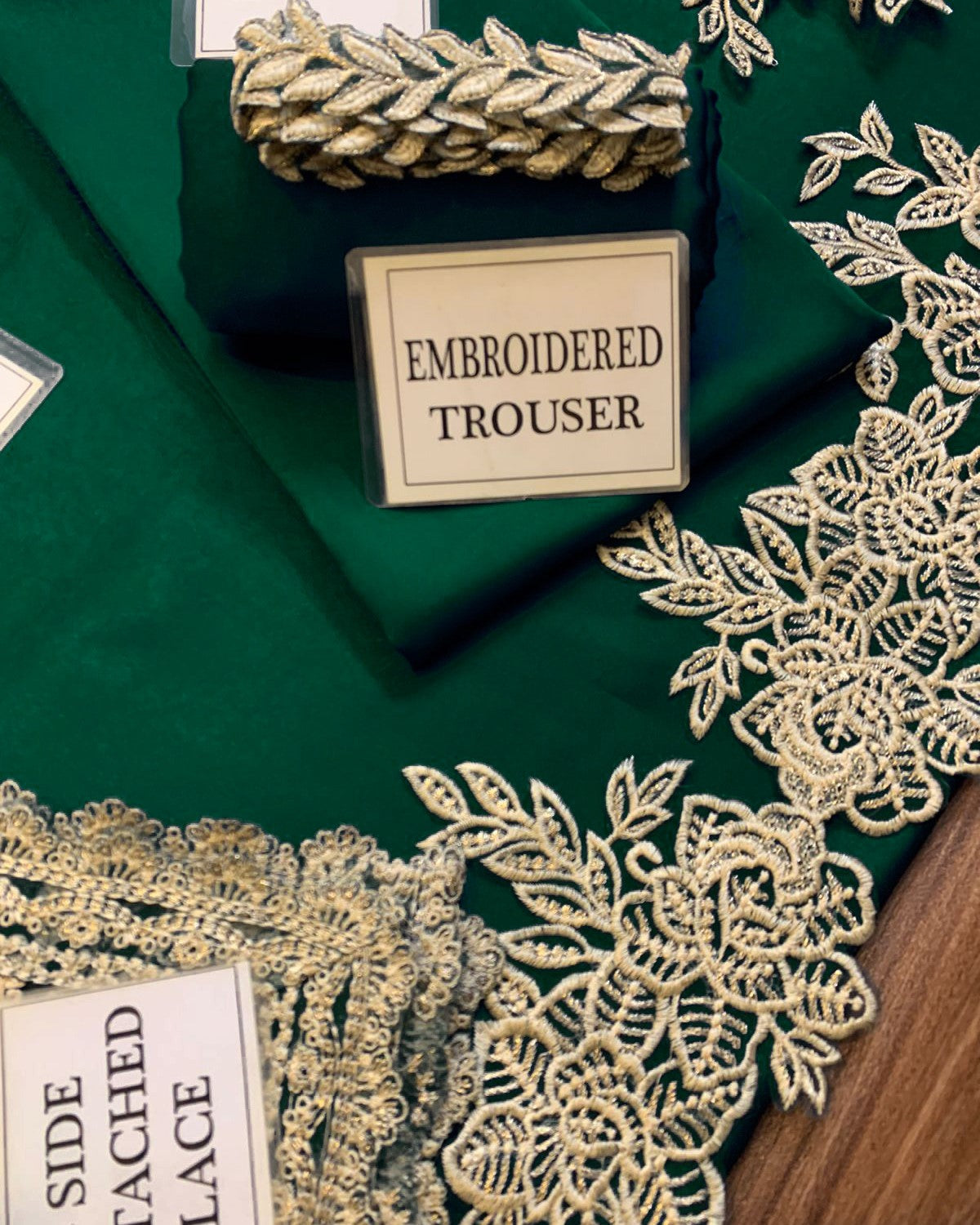 Embroidered fabric with gold lace on a green background