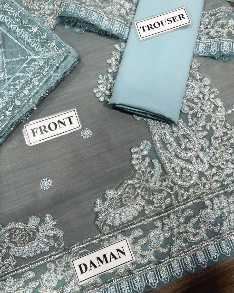 Embroidered fabric with labels for daman, front, and trouser on a gray background