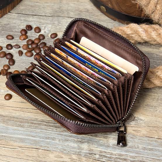 Elegant black wallet with zipper and matching cardholder placed on a table
Spacious brown wallet with top zip open showing inner compartments