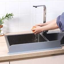 Person stretching the silicone splash guard showing its flexibility in a clean kitchen.
Water flowing inside the sink with splash guard preventing overflow onto the countertop.