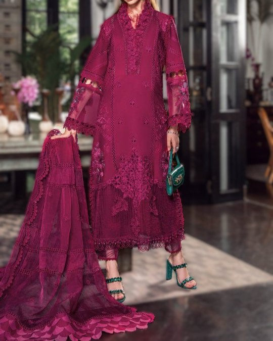 Woman wearing a burgundy lace dress with a green handbag indoors.